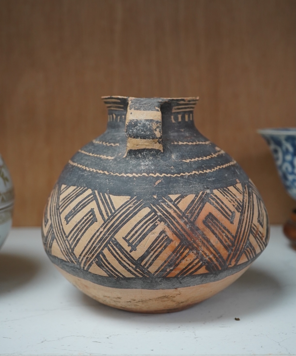 A Chinese neolithic pottery two handled jar - 14cm tall, Provenance: the vendor‘s parents lived in Hong Kong from 1947 and bought the jar from a specialist dealer before 1980. Condition - fair to good